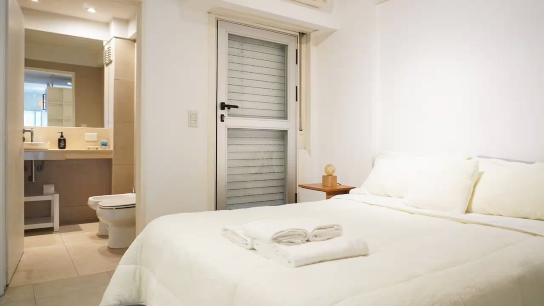 Quarto com cama de casal e banheiro